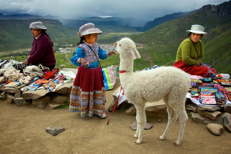 路上遇见了穿着传统服饰的妇女和女孩，她们身边的羊驼是供游客拍照赚钱的。
