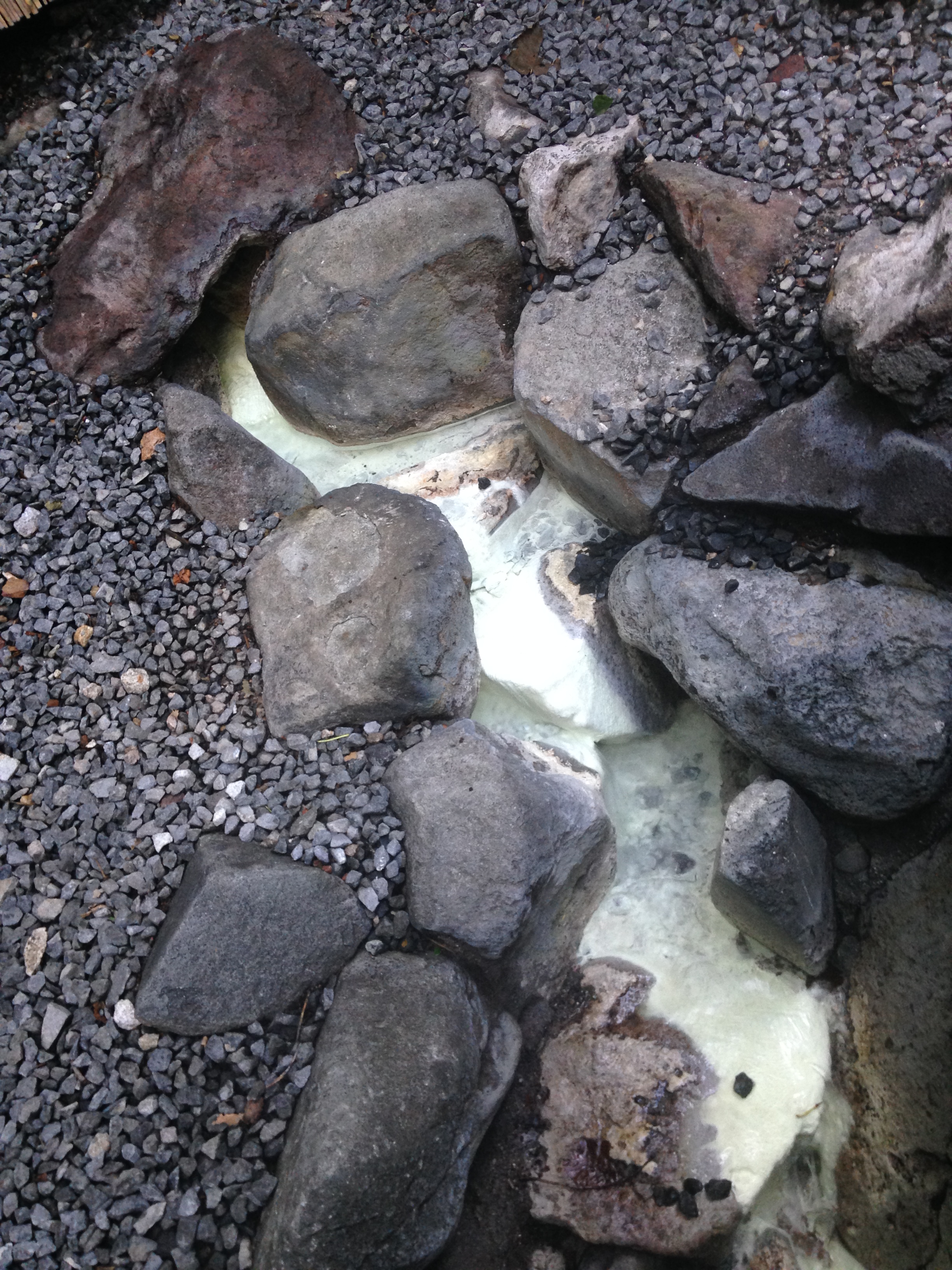 沿着溪流涌下乳白色的硫磺温泉水。