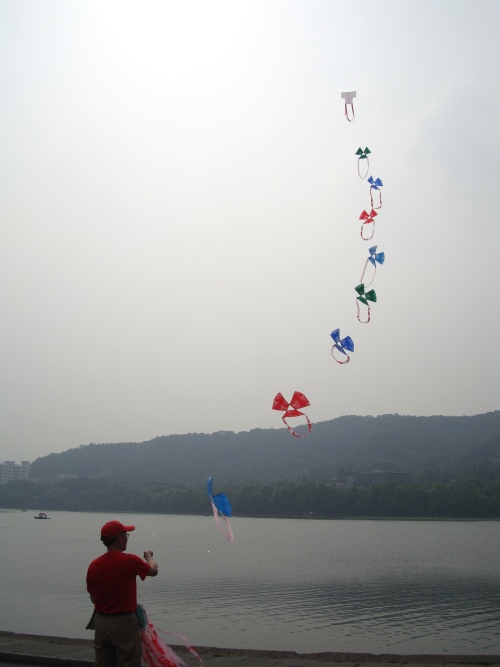 一串风筝，在西湖边飞翔。