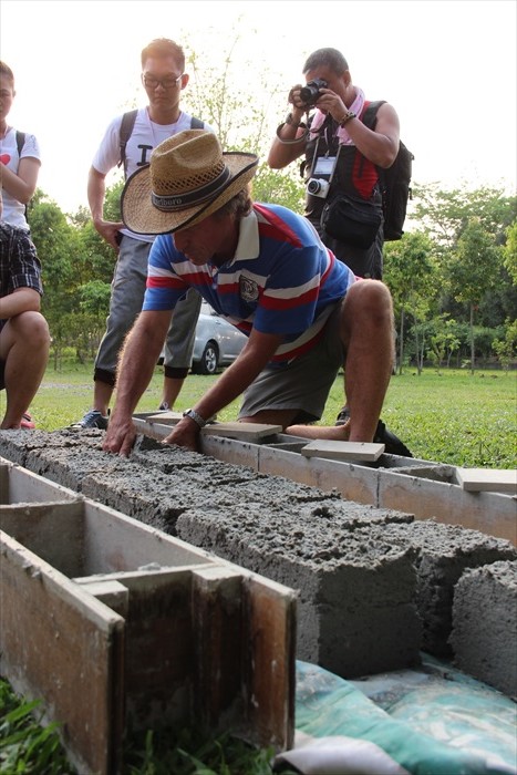 罗约翰在示范使用旧报纸及采​​用水泥混合成泥浆制出的砖块过程。